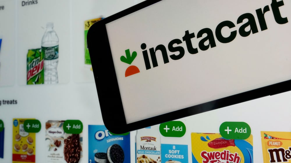 FILE - An instacart logo and an instacart webpage are seen in New York, Sept. 6, 2023. (AP Photo/Richard Drew, File)