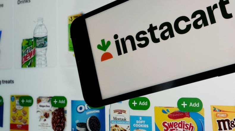FILE - An instacart logo and an instacart webpage are seen in New York, Sept. 6, 2023. (AP Photo/Richard Drew, File)