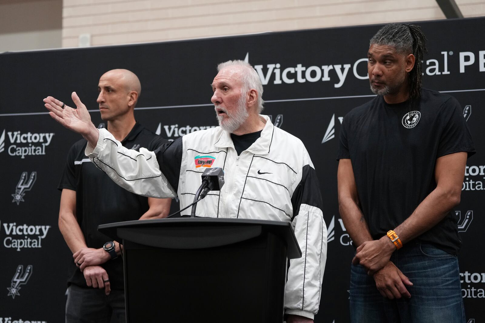 With the help of former players Manu Ginobili, left, and Tim Duncan, right, former San Antonio Spurs head coach Gregg Popovich, center, introduces Mitch Johnson as the new head coach of the San Antonio Spurs NBA basketball team, in San Antonio, Monday, May 5, 2025. (AP Photo/Eric Gay)
