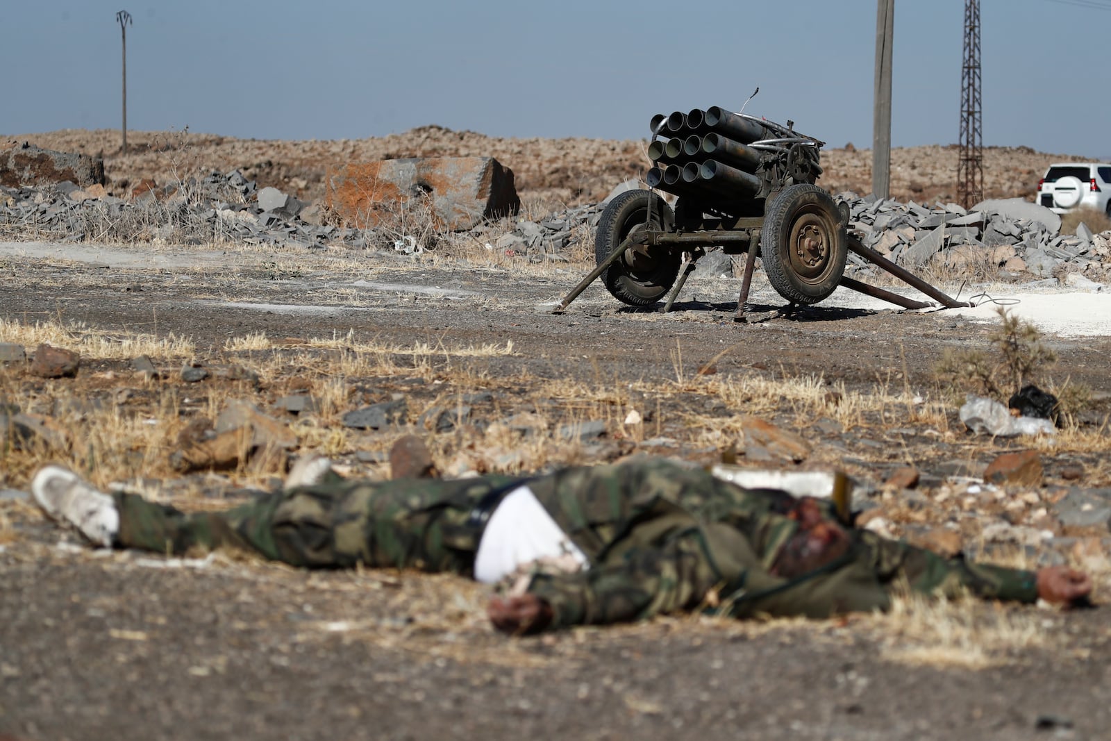 A dead fighter of the Druze militias lies on the ground in front of a rocket launcher on the outskirts of Sweida city, where clashes erupted between Sunni Bedouin clans and Druze militias, southern Syria, Monday, July 14, 2025. (AP Photo/Omar Sanadiki)