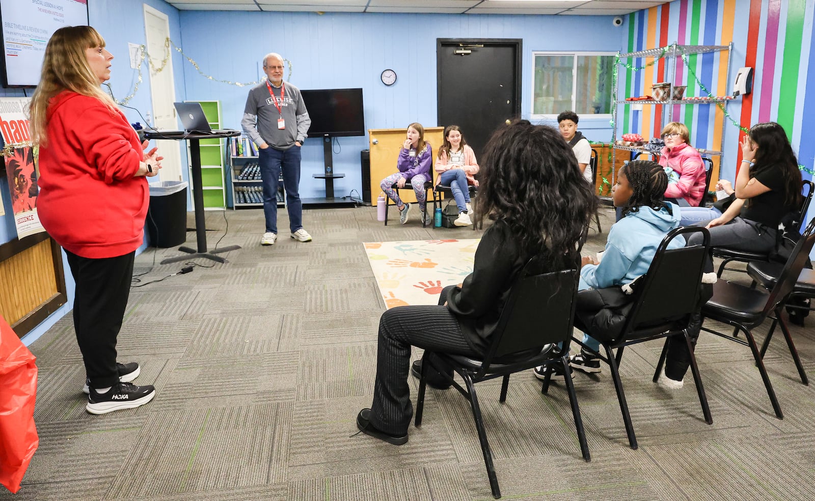 Donna Beer (far left), a volunteer, talks to Ruskin Elementary School students on Tuesday, Jan. 6, at a Dayton church. Beer was assisting teaching students during a LifeWise Academy class. LifeWise is a Hilliard-based organization that offers Christian education to public school students during school hours at sites near school buildings. BRYANT BILLING/STAFF