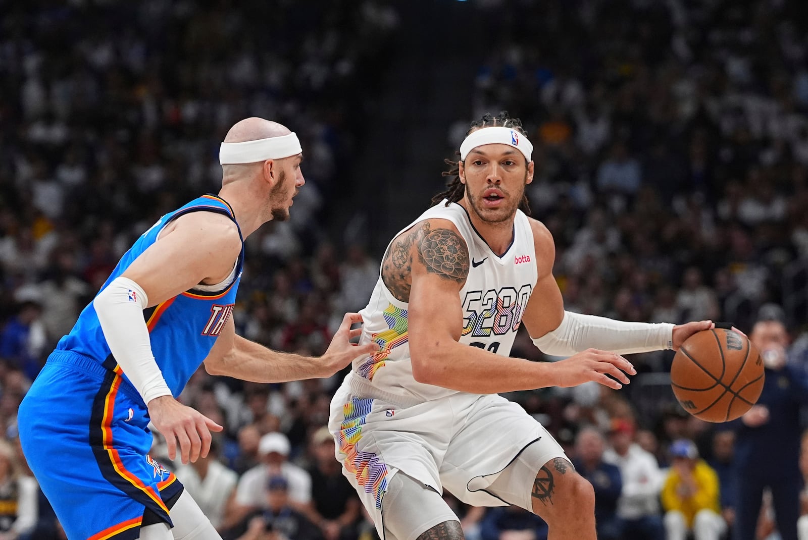 Denver Nuggets forward Aaron Gordon, right, drives to the basket as Oklahoma City Thunder guard Alex Caruso defends in the first half of Game 6 in the Western Conference semifinals of the NBA basketball playoffs Thursday, May 15, 2025, in Denver. (AP Photo/David Zalubowski)