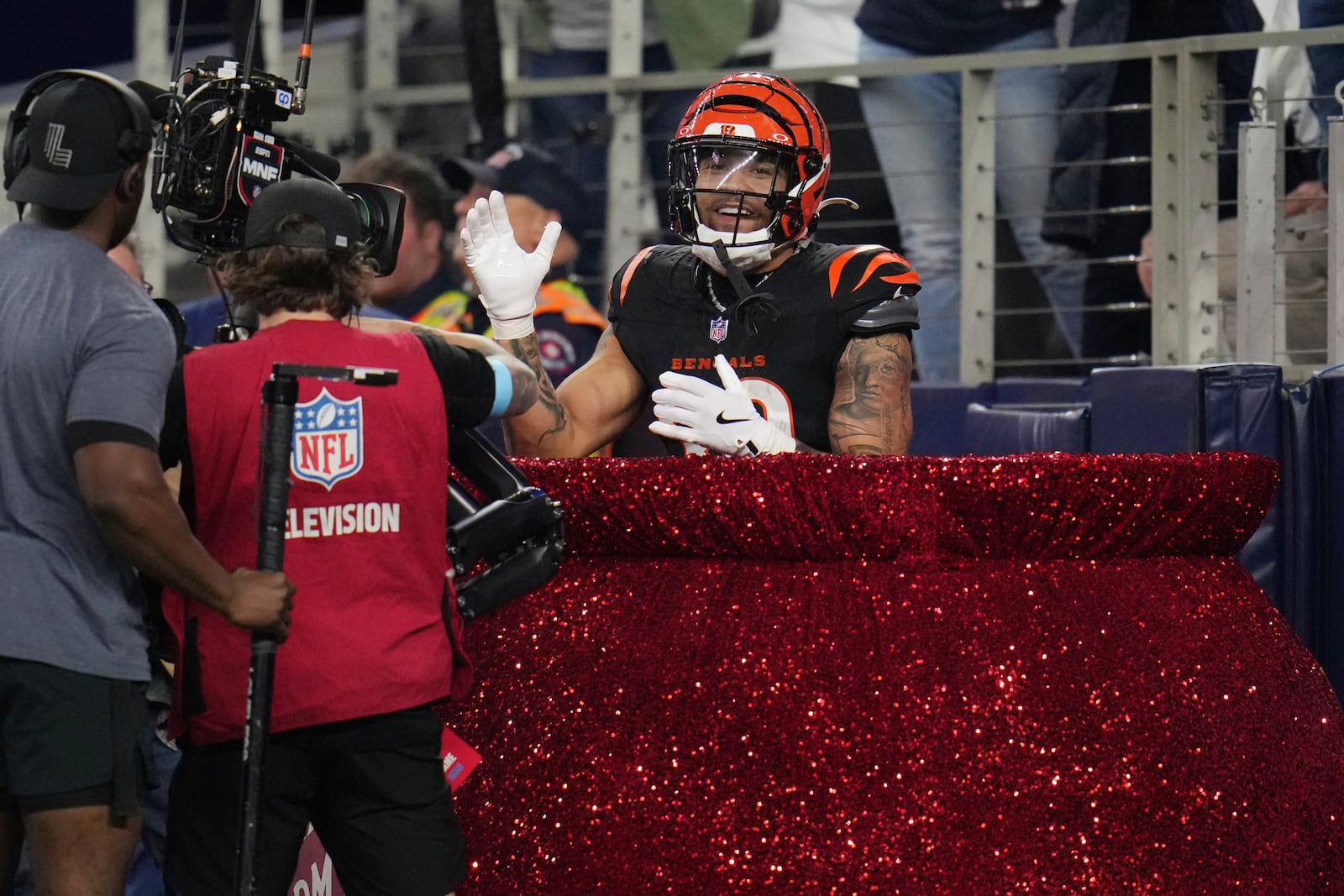 Cincinnati Bengals running back Chase Brown celebrates scoring a touchdown in a Salvation Army Kettle during the first half of an NFL football game against the Dallas Cowboys, Monday, Dec. 9, 2024, in Arlington, Texas. (AP Photo/Julio Cortez)