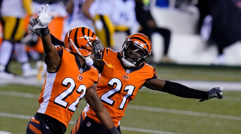 Cincinnati Bengals' Mackensie Alexander (21) and William Jackson (22) celebrate after Pittsburgh Steelers turned the ball over on downs during the second half of an NFL football game, Monday, Dec. 21, 2020, in Cincinnati. (AP Photo/Michael Conroy)