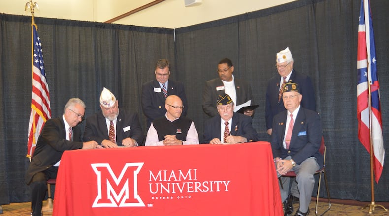 Miami President Gregory Crawford (seated center) and Buckeye Boys State Director Jerry White (right of Crawford) were among signers of the contract bringing the annual program to Miami University’s Oxford campus starting next June. CONTRIBUTED/BOB RATTERMAN