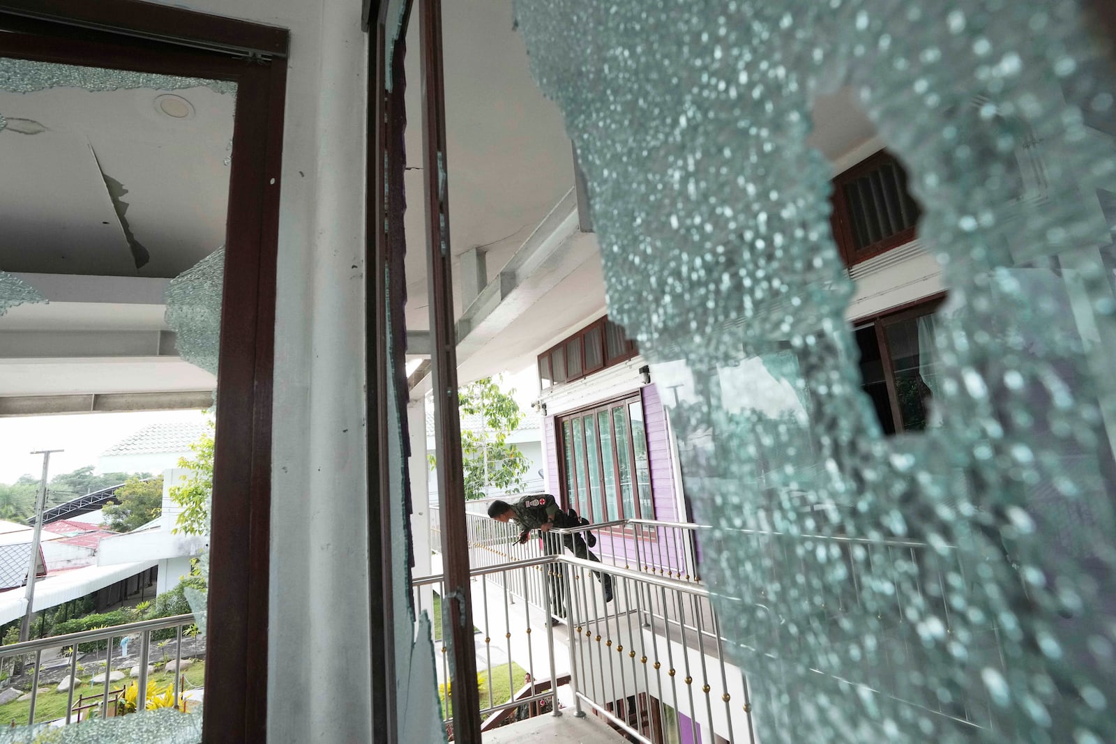 A Thai soldier stands at the Phanom Dong Rak hospital damaged after Cambodia fired artillery shells in Surin Province, Thailand, Friday, July 25, 2025. (AP Photo/Sakchai Lalit)