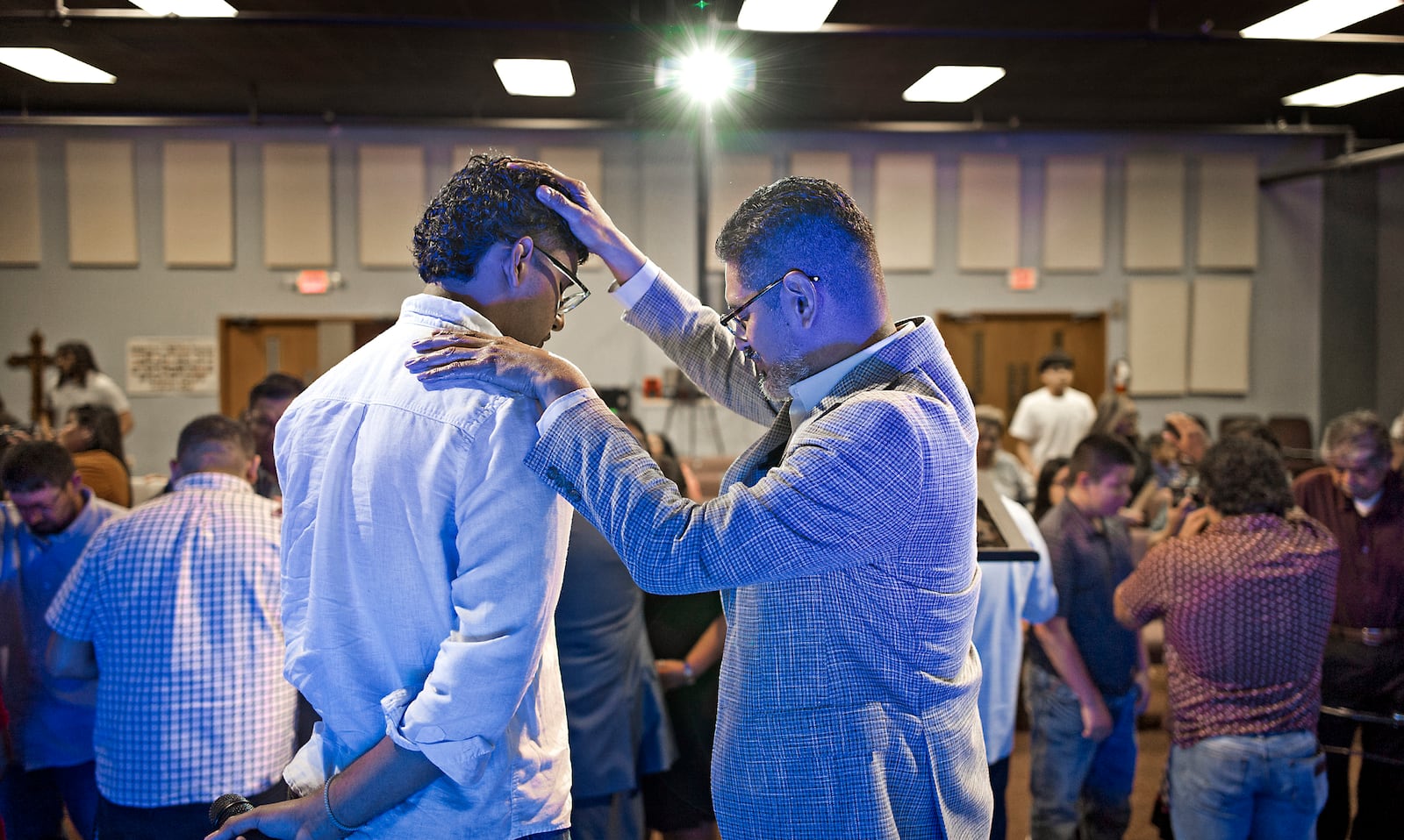José Luis Orozco, a pastor from Nicaragua, places his hand on his son, Josias, 17, as he prays for him and the congregation of the Oasis Church, in Taylor, Texas, June 15, 2025. (AP Photo/Rodolfo Gonzalez)