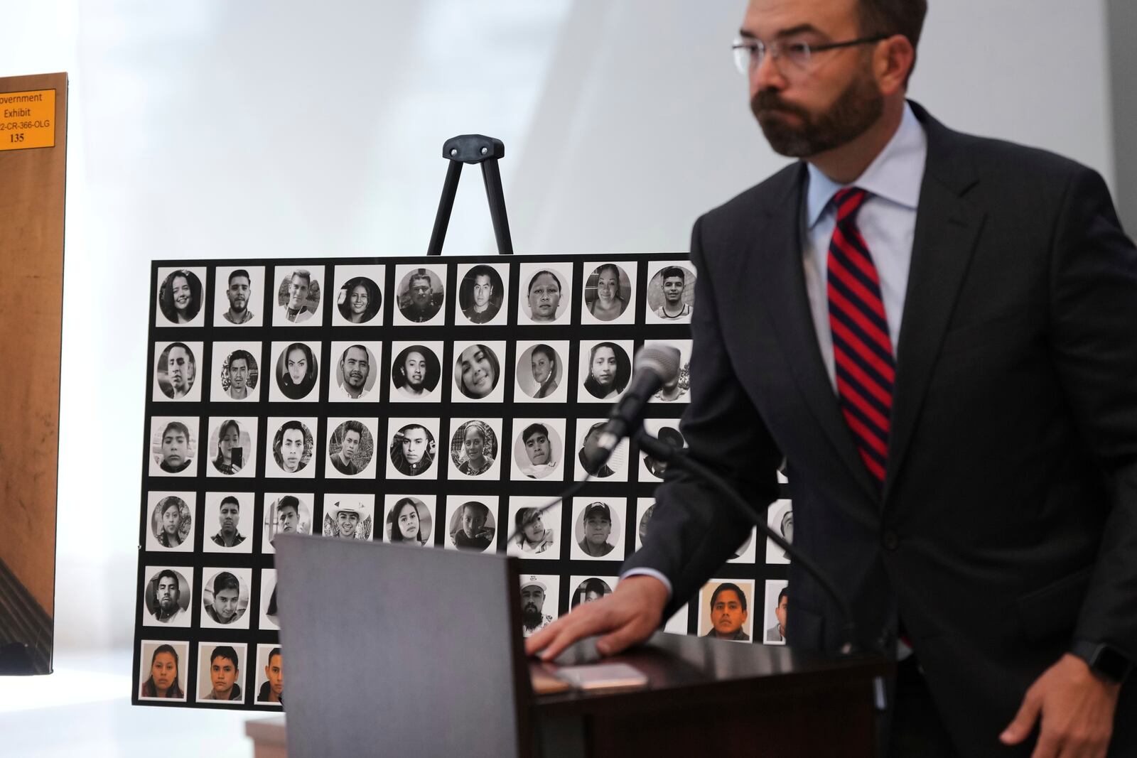 Photos of victims are displayed as U.S. Attorney for the Western District of Texas Justin Simmons holds a news conference following the the sentence hearing for Felipe Orduna-Torres and Armando Gonzales-Ortega, smugglers connected to an operation that led to the deaths of 53 migrants in the back of a tractor-trailer, Friday, June 27, 2025, in San Antonio. (AP Photo/Eric Gay)