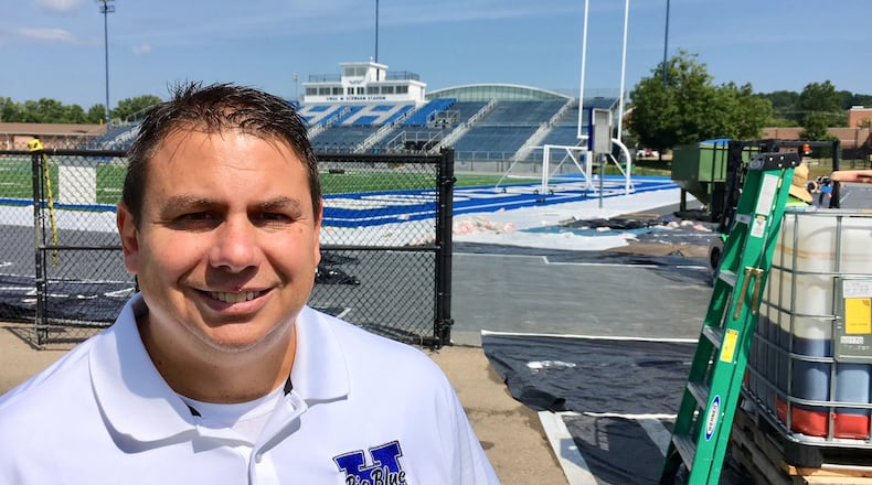 Hamilton High School Athletic Director Todd Grimm checks out the progress on the previously delayed replacement of the track at Virgil M. Schwarm Stadium. Heavy rains during the summer break pushed back the track’s scheduled opening, forcing some of the school’s sports teams to play elsewhere. MICHAEL D. CLARK/STAFF