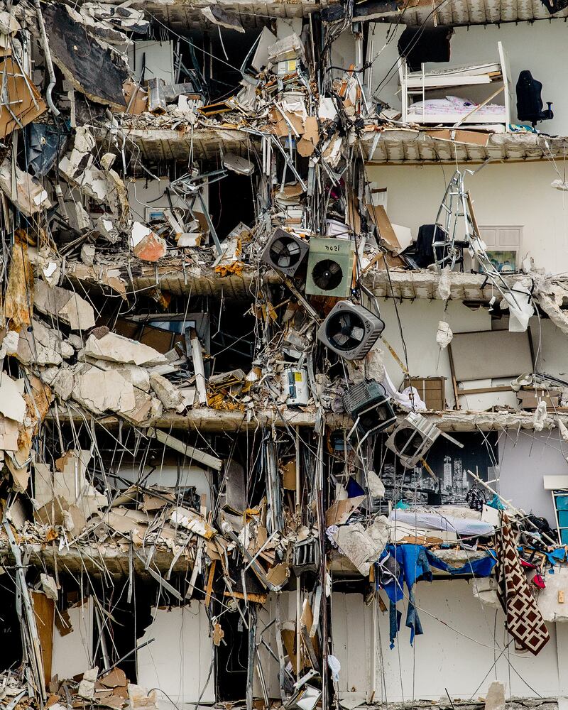 Air conditioning units, and personal belonging hang from a high-rise residential building that is partially collapsed in Surfside, Fla., Thursday, June 24, 2021. (Scott McIntyre/The New York Times)