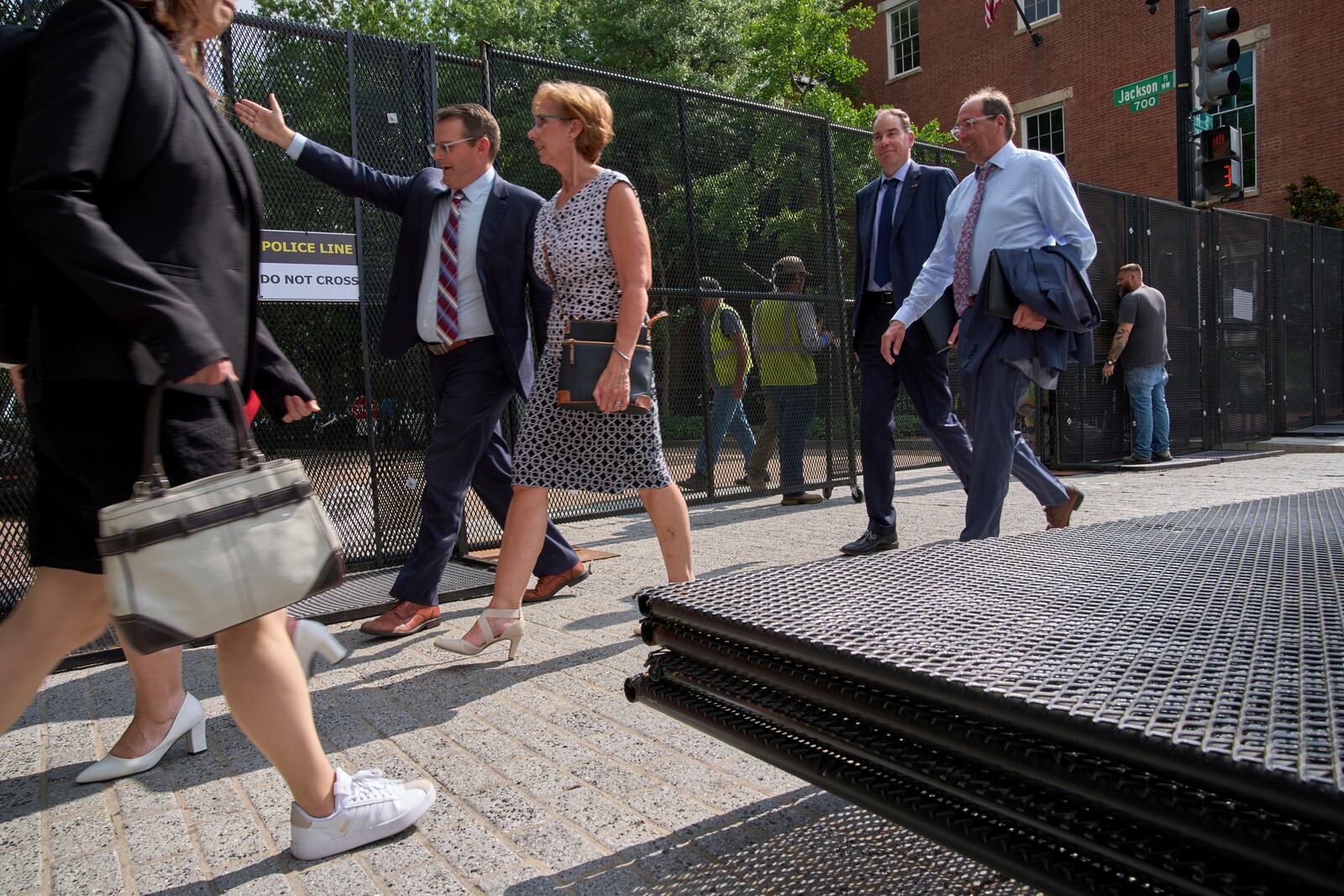 People walk by security fencing as it is installed around Lafayette Park and the White House during security preparations for a festival and parade to commemorate the 250th Birthday of the U.S. Army, Monday, June 9, 2025, in Washington. (AP Photo/Jacquelyn Martin)