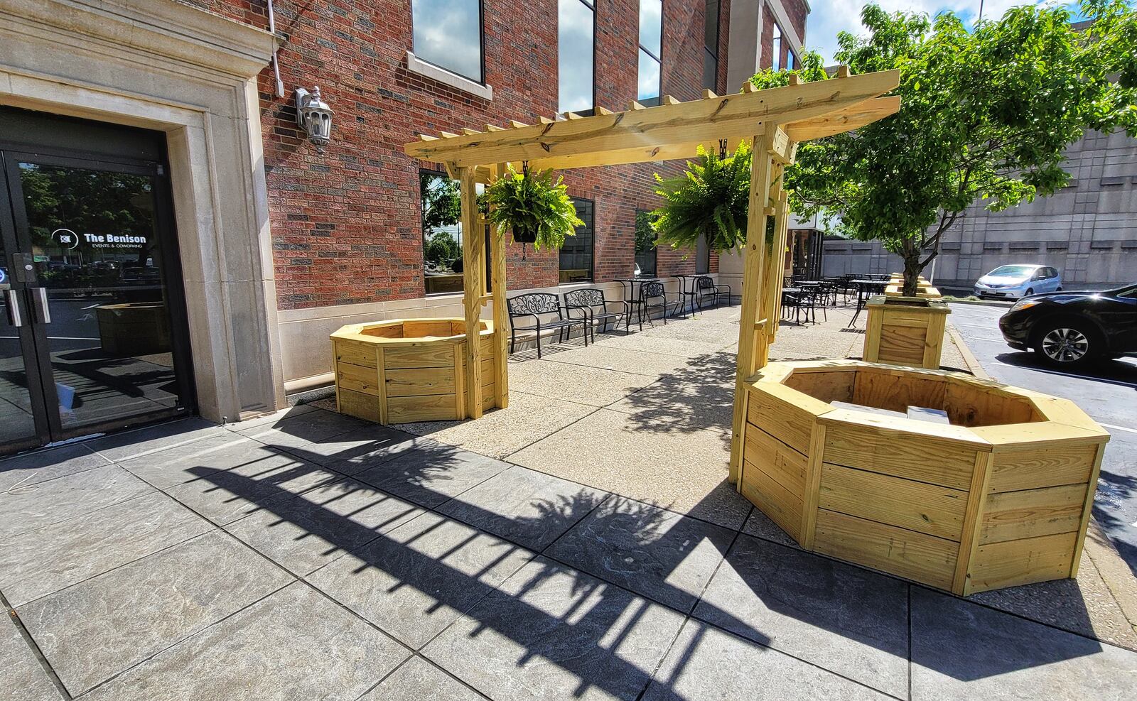The Benison event center and co-working space in Hamilton has added flower planters in an outdoor seating area and a metal carriage with the help of Butler Tech carpentry program at Hamilton High School and Butler Tech welding students. NICK GRAHAM / STAFF