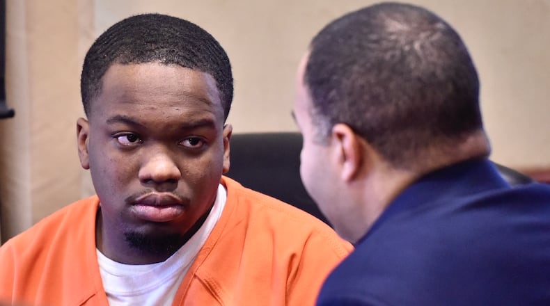 Eric Brown, charged with murder in a May shooting death in St. Clair Twp., takes with his attorney Lawrence Hawkins III during a hearing today in Butler County Common Pleas Court. NICK GRAHAM/STAFF