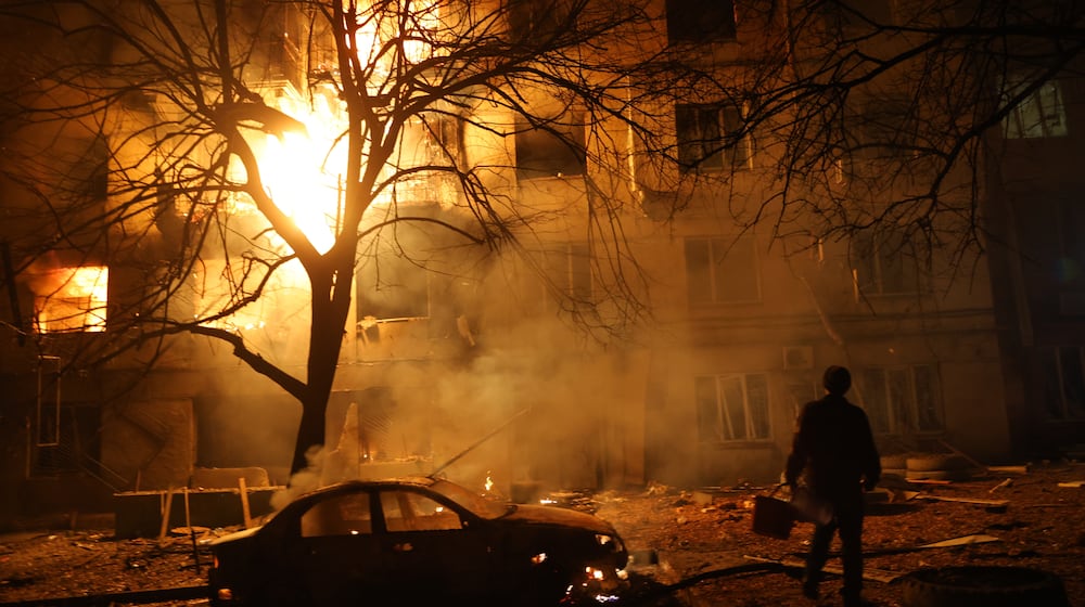 A man walks in front of burning residential building after a Russian attack on Zaporizhzhia, Ukraine, Wednesday, Nov. 26, 2025. (AP Photo/Kateryna Klochko)