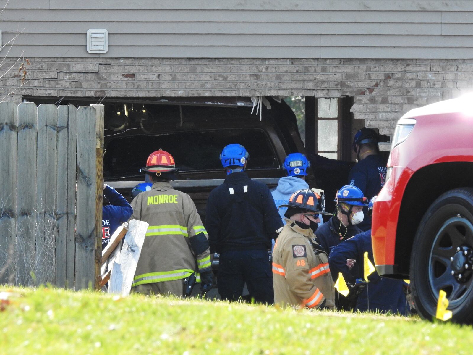 Emergency units work to remove a truck that slammed into a Monroe house this morning NICK GRAHAM/STAFF