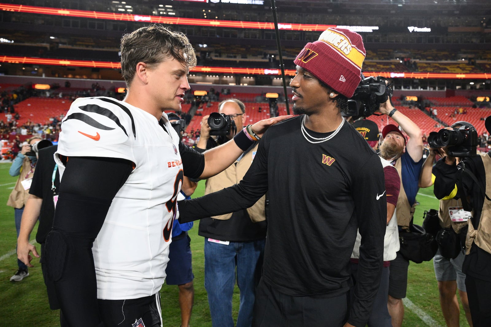 Cincinnati Bengals quarterback Joe Burrow, left, and Washington Commanders quarterback Jayden Daniels talk following a preseason NFL football game Monday, Aug. 18, 2025, in Landover, Md. (AP Photo/Nick Wass)