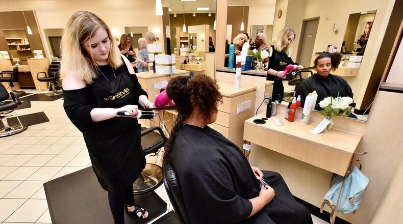 Kathlene Riggs styles Yazmyne Richardson’s hair at Salon InStyle inside JCPenney at Bridgewater Falls. The revamped salon opened Friday, June 15, 2018, at the store. The JCPenney store in Fairfield Twp. is one of 100 locations nationwide to receive the updated salon concept this year. NICK GRAHAM/STAFF