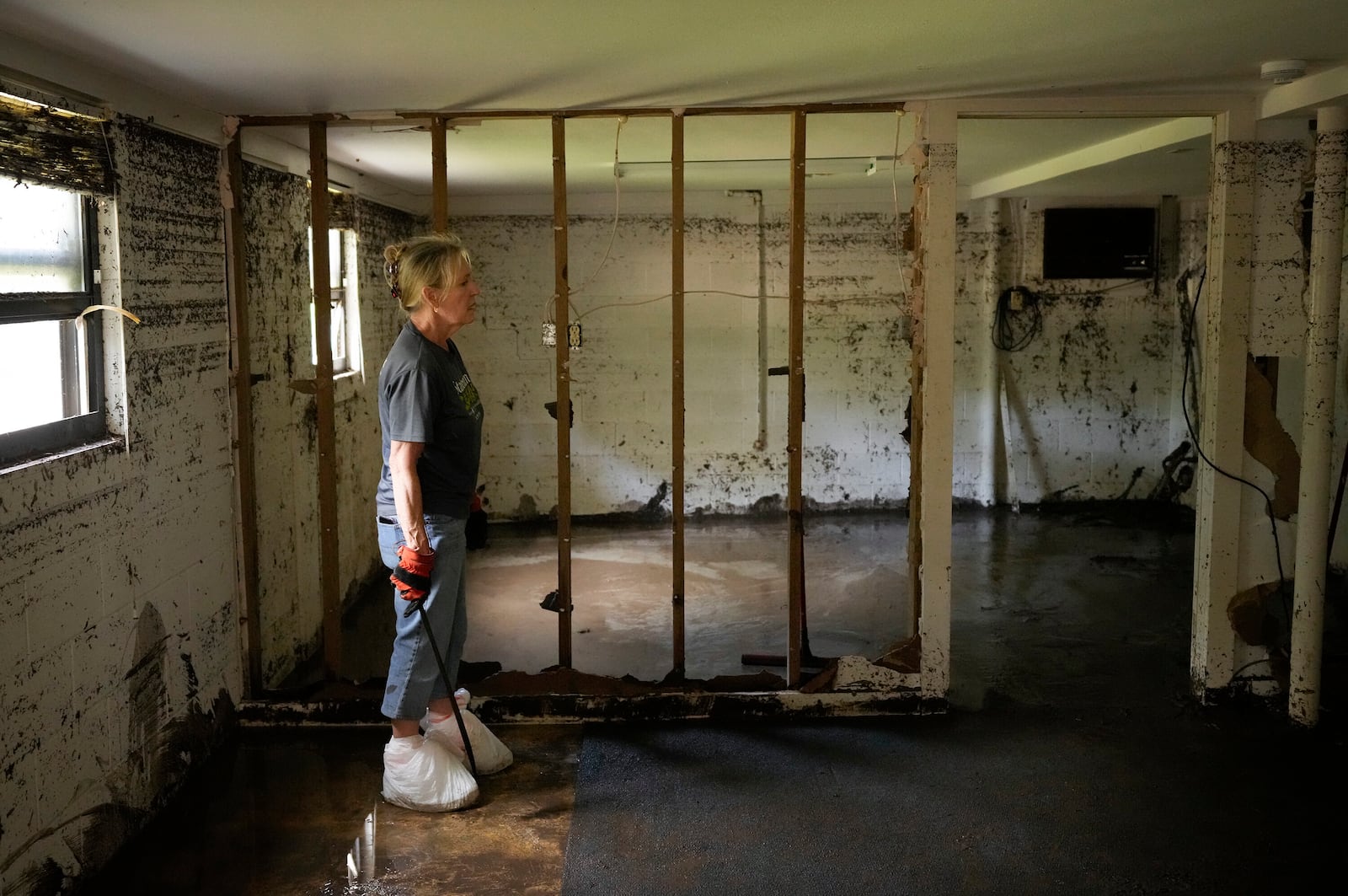 Debbie Sander looks at the damage to her mother's house in Ingram, Texas, Tuesday, July 8, 2025, after it was flooded with more than six feet of water during the Fourth of July flood. (Jay Janner/Austin American-Statesman via AP)