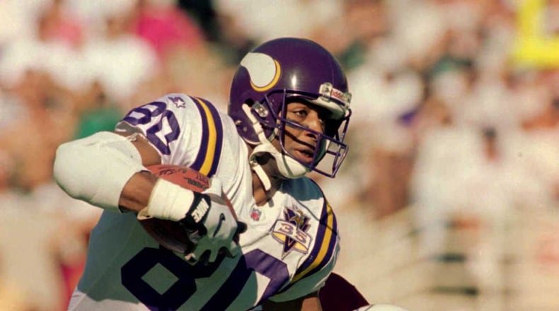 Arizona Cardinals defensive back Tito Paul, right, tries to bring down Minnesota Vikings wide receiver Chris Carter during their game in Tempe, Ariz., Sunday Nov. 12, 1995. Minnesota won the game in overtime 30-24. (AP Photo/Scott Troyanos)