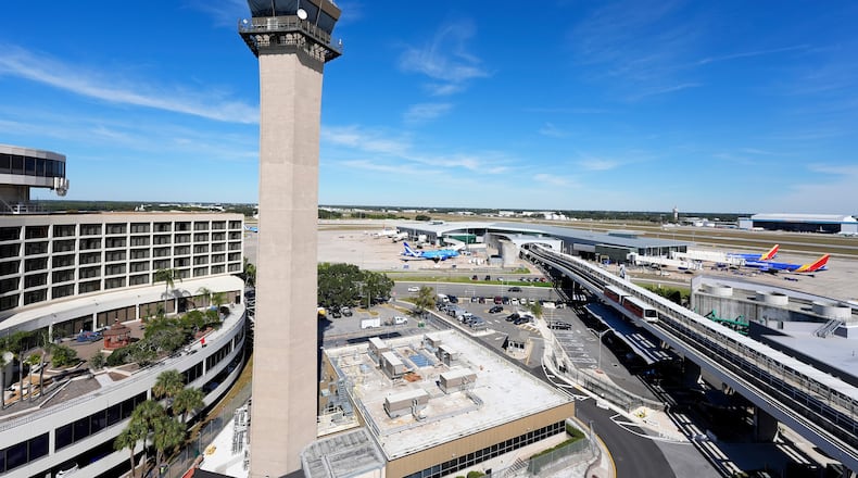 FILE - Airplanes are parked at gates near the air traffic control tower at the Tampa International Airport, Nov. 11, 2025, in Tampa, Fla. (AP Photo/Chris O'Meara, File)