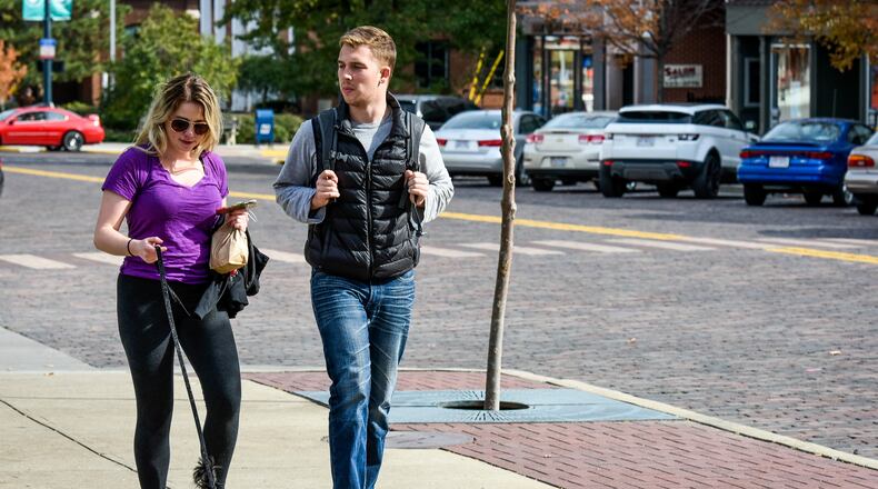 It’s been a banner year of national recognition for Butler County’s Miami University. The latest honor comes from a study cited by Forbes magazine, which picked the school’s Oxford campus community as America’s best, small college town. Samantha Bettinger walks with McCormick Lucke and her Maltese Yorkie, Lu Lu, along High Street in October in Oxford. NICK GRAHAM/STAFF