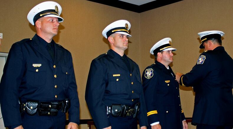 West Chester Police Chief Joel Herzog, far right, performs the honors at an Oct. 11 pinning ceremony to mark the promotions of three West Chester Police officers from left, Paul Brent Lovell, promoted to Sergeant; Christopher Whitton, promoted to Lieutenant; and Joseph Gutman, promoted to Captain. CONTRIBUTED