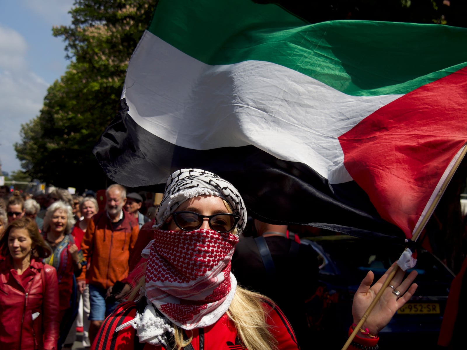 A demonstrator holds a Palestinian flag during the Red Line protest in The Hague, Netherlands on Sunday, May 18, 2025. (Niels van der Pas via AP)
