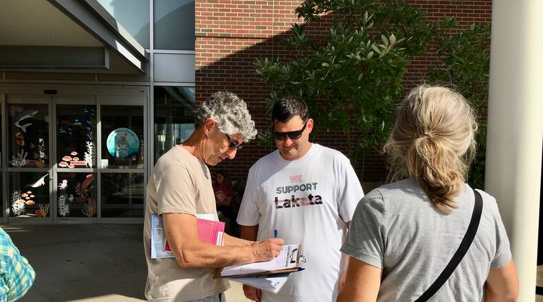 The embattled Lakota school board member Darbi Boddy, who has already been asked by colleagues to resign and was censured by them, is now the target of a growing public petition-gathering effort by critics seeking to remove her from office. Pictured is one of the leaders of the Recall Darbi Boddy effort, Alex Argo (center) gathering petition signatures recently outside of MidPointe Library. Argo is a Lakota school parent who says Boddy's many clashes with fellow members and district officials are hurting the 17,000-student district. (Photo By Michael D. Clark\Journal-News)