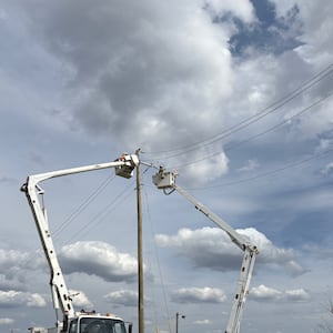 Crews work on a utility pole after thunderstorms and high winds March 11-16, 2026. AES / PROVIDED