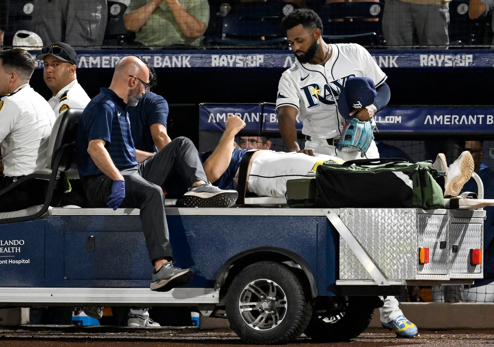 Tampa Bay Rays' Junior Caminero, right, stands teammate with Hunter Bigge as Bigge is taken off the field after being hit by a foul ball while in the dugout during the seventh inning of a baseball game against the Baltimore Orioles, Thursday, June 19, 2025, in Tampa, Fla. (AP Photo/Jason Behnken)