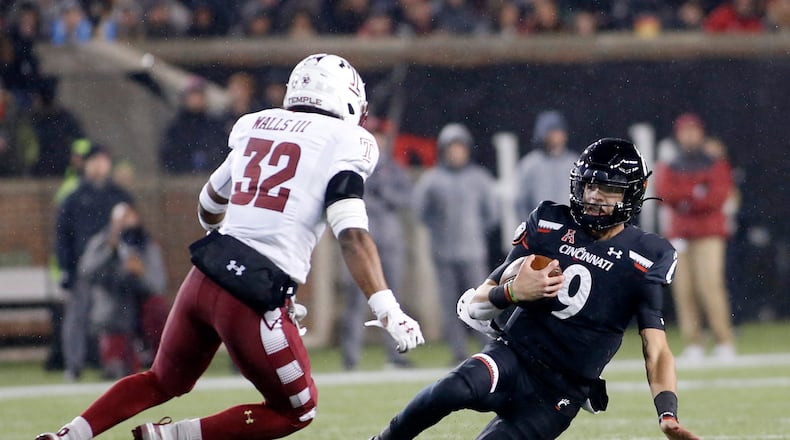CINCINNATI, OHIO - NOVEMBER 23: Desmond Ridder #9 of the Cincinnati Bearcats avoids a tackle from Benny Walls #32 of the Temple Owls during the second quarter at Nippert Stadium on November 23, 2019 in Cincinnati, Ohio. (Photo by Justin Casterline/Getty Images)