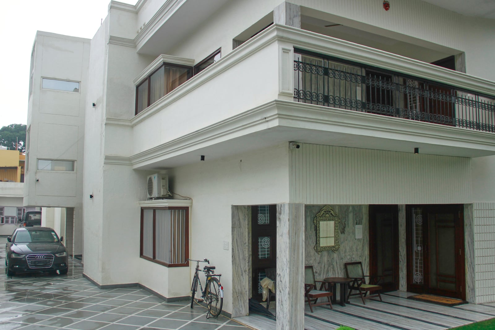 A luxury car and a bicycle are seen parked outside a rented residential building in which a bogus embassy was running in Ghaziabad, outskirts of New Delhi, India, Wednesday, July 23, 2025. (AP Photo)