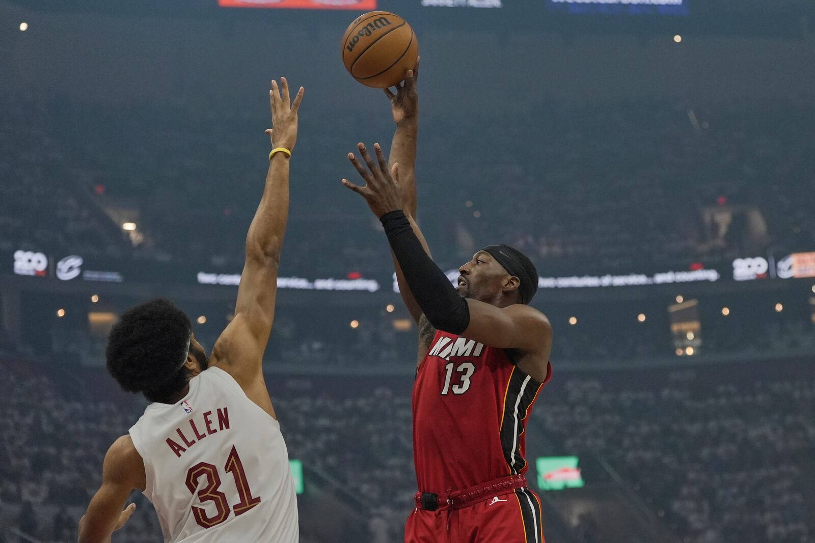 Miami Heat center Bam Adebayo (13) shoots over Cleveland Cavaliers center Jarrett Allen (31) in the first half in Game 1 of an NBA first-round playoff series, Sunday, April 20, 2025, in Cleveland. (AP Photo/Sue Ogrocki)