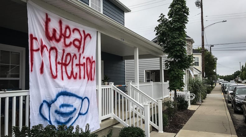 A sign on the University of Dayton housing in March 2020 urges mask wearing. FILE