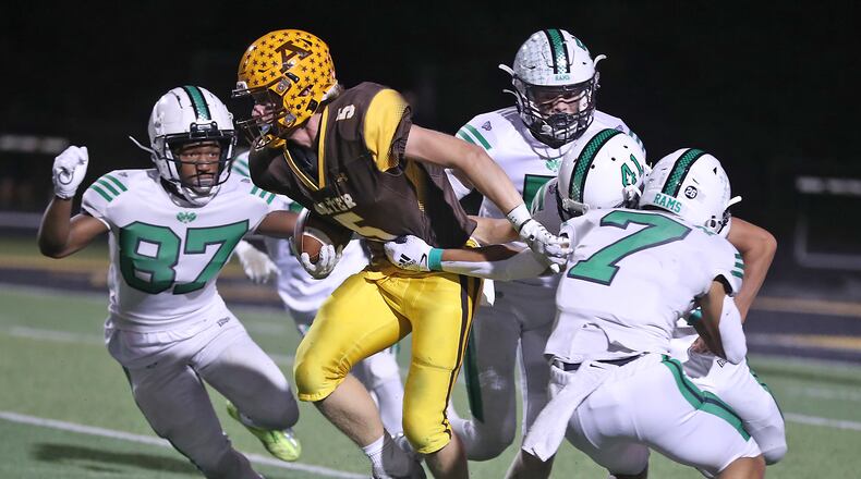 Alter's Michael Russ is swarmed by a pack of Badin defenders during a game at Centerville High School on Sept. 30, 2022. Bill Lackey/STAFF