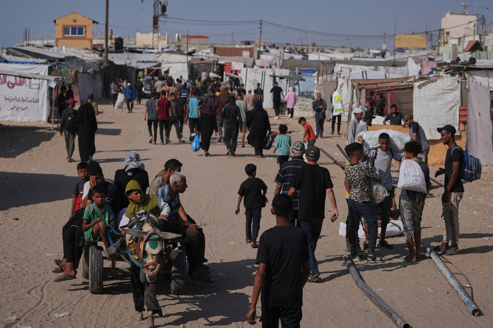 Displaced Palestinians carrying their belongings in Rafah, southern Gaza Strip on Saturday, June 7, 2025. (AP Photo/Jehad Alshrafi)
