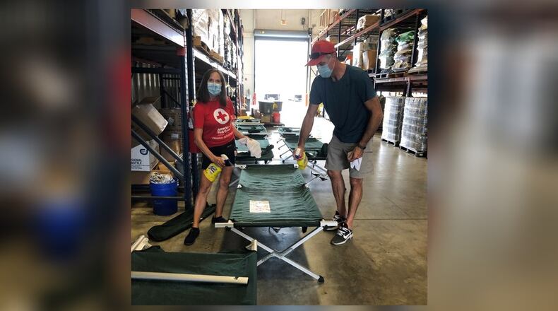 Mark and Mary Howell, a married couple of Centerville, Ohio sanitize cots at a Red Cross warehouse in Baton Rouge, LA. Mark is a shelter supervisor, Mary is shelter service associate. CONTRIBUTED