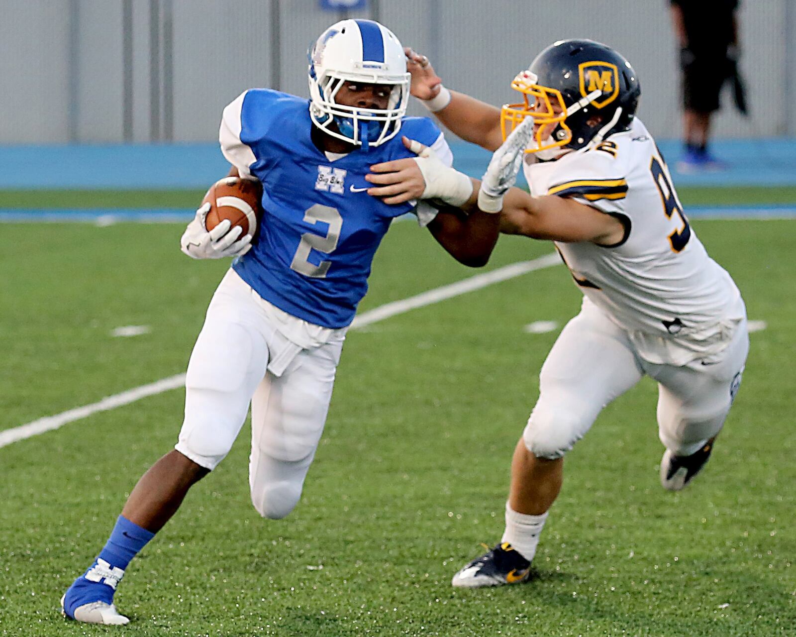 Hamilton’s DaQuan Maffett is caught for a loss by Moeller’s Gabriel Jacon Duffy during Saturday night’s Skyline Chili Crosstown Showdown game at Virgil Schwarm Stadium in Hamilton.CONTRIBUTED PHOTO BY E.L. HUBBARD