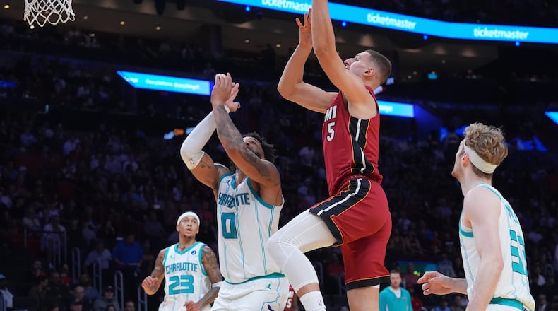 Miami Heat guard Pelle Larsson (9) drives to the basket over Charlotte Hornets forward Miles Bridges (0) during the first half of an NBA Cup basketball game Friday, Nov. 7, 2025, in Miami. (AP Photo/Marta Lavandier)