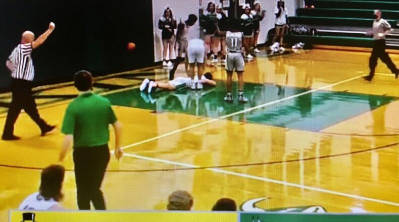 A screen shot photo from a game video posted online by Butler County Sports Report shows an Cincinnati Oyler High School player standing over a New Miami High School player he just fouled. Officials from both schools continued to investigate the Oyler player's alleged kicking of the prone New Miami player in the head. (Butler County Sports Report image)