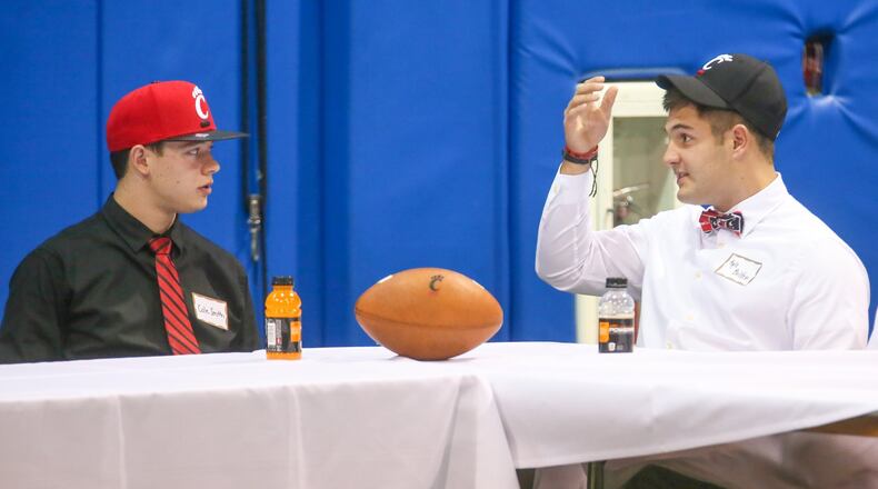 Middletown’s Cole Smith (left), who will be attending the University of Cincinnati, talks with future teammate Kyle Bolden of Colerain during Wednesday’s National Signing Day event hosted by the Greater Miami Conference football coaches at Beacon Orthopaedics and Sports Medicine in Sharonville. GREG LYNCH/STAFF