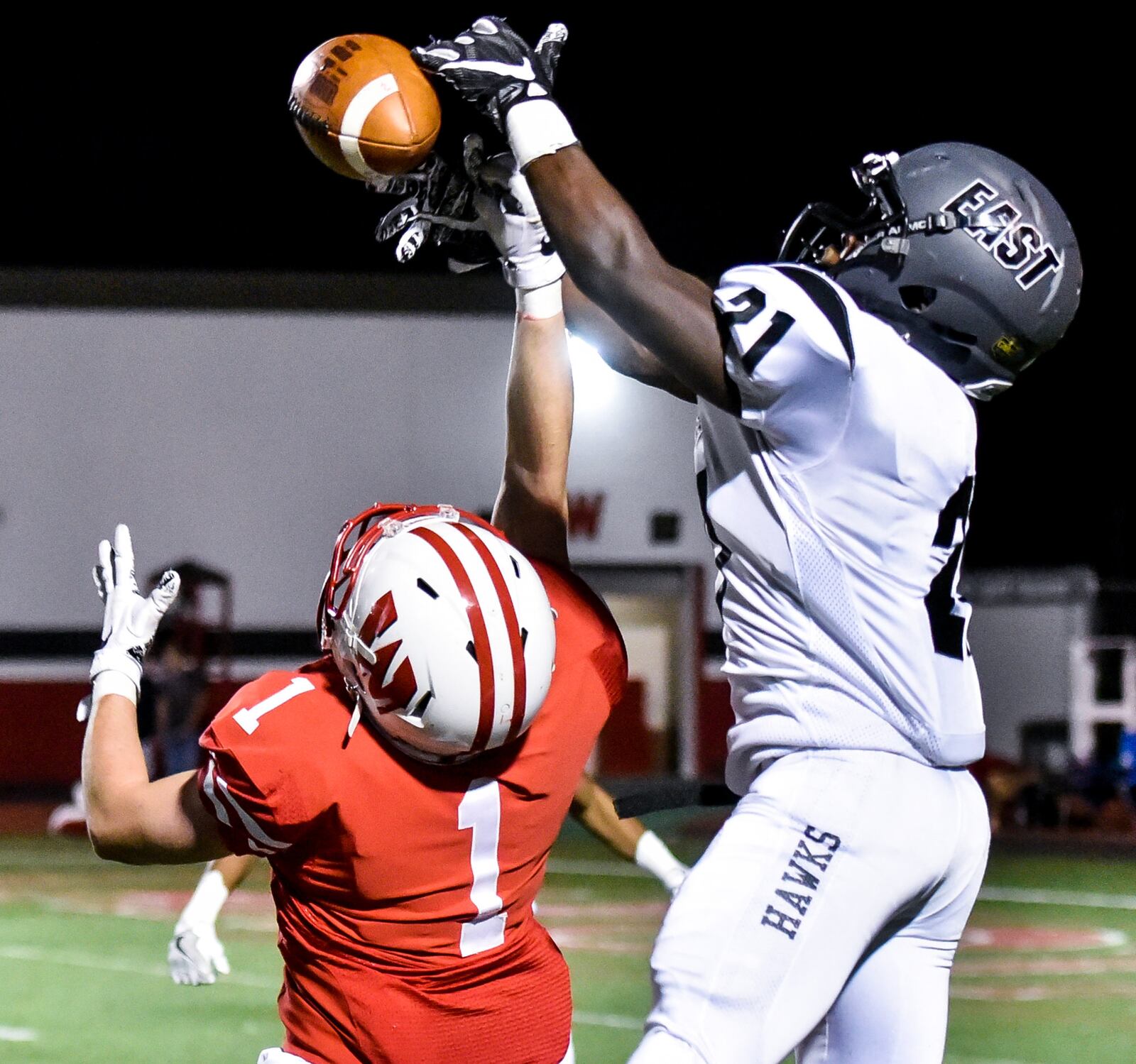 Lakota East's Quinton Moss Jr. (21) nearly intercepts a pass intended for Lakota West's Mike Wagner (1) during their game Friday night at West. NICK GRAHAM/STAFF