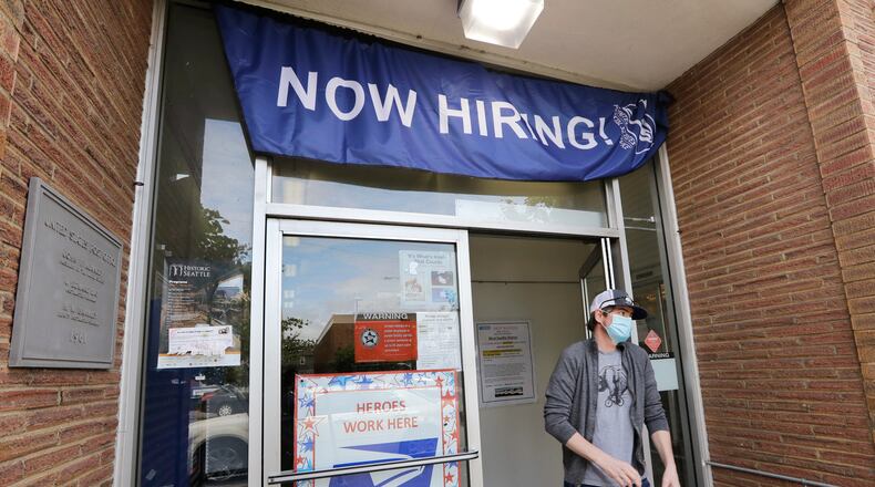 A customer walks out of a U.S. Post Office branch in Seattle. AP Photo/Elaine Thompson, File