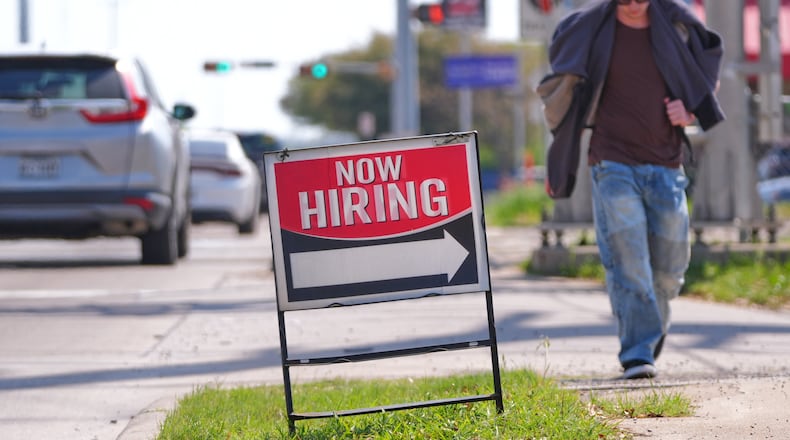 A now hiring sign sits on the side of the road in Garland, Texas, Monday, March 23, 2026. (AP Photo/LM Otero)