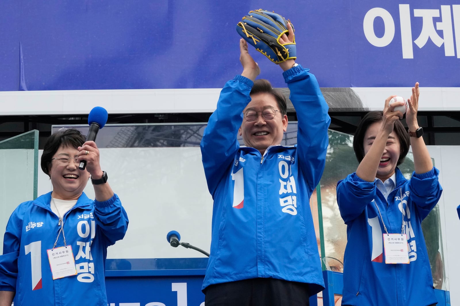 South Korea's Democratic Party's presidential candidate Lee Jae-myung, center, reacts after hurling a baseball ball during a presidential election campaign at Jamsil Sports Complex in Seoul, South Korea, Thursday, May 29, 2025. (AP Photo/Ahn Young-joon)
