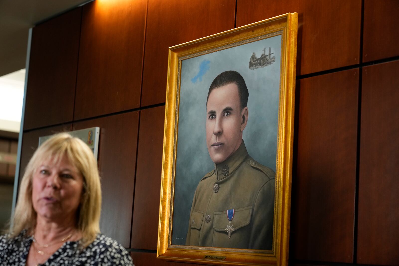 Ms. Sue Conger-Williams, Fred Benning's granddaughter gives and interview in front of her grandfathers portrait hanging at Fort Benning during a ceremony honoring new namesake on Wednesday, April 16, 2025, in Fort Benning, Ga. (AP Photo/Brynn Anderson)