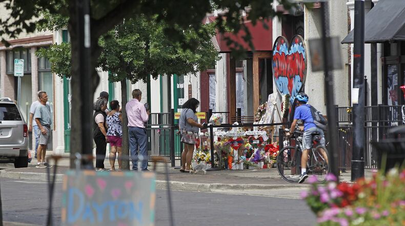 Memorials to victims of the mass shooting on August 4 have begun to shrink in the Oregon District and some business owners would like to have them removed. Many people continued to visit the memorials during the Friday lunch hour. TY GREENLEES / STAFF