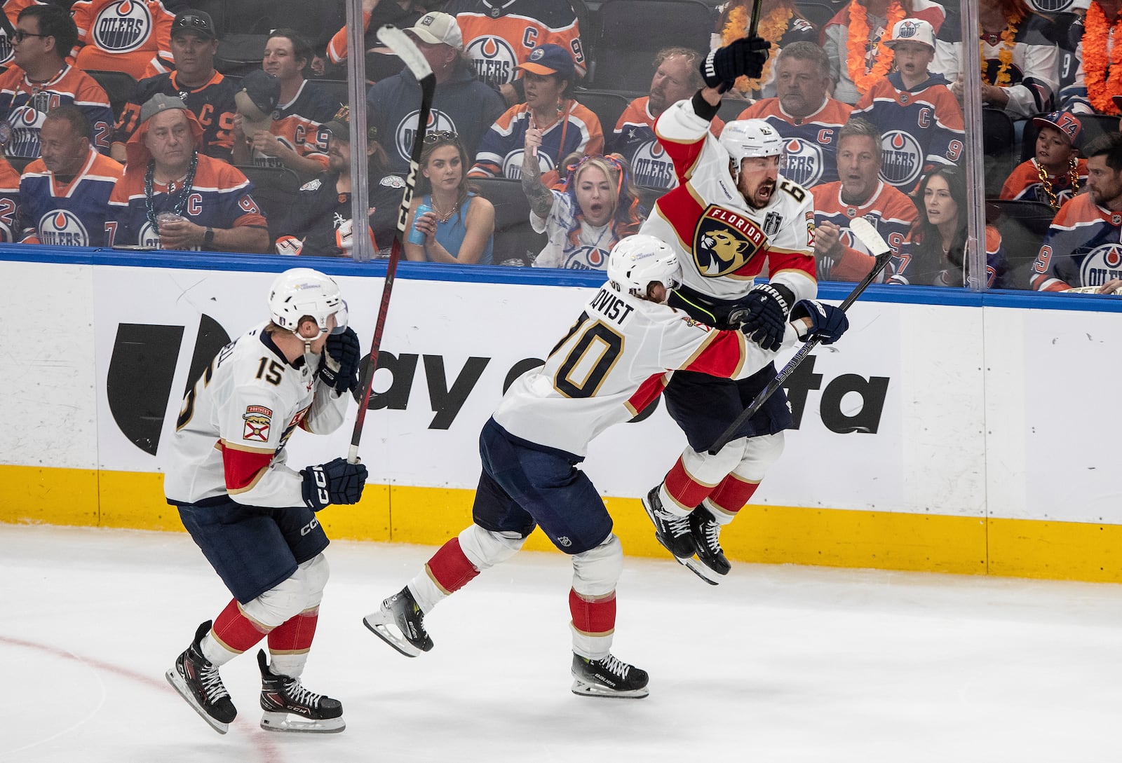Florida Panthers' Brad Marchand (63) celebrates his game-winning goal against the Edmonton Oilers with Jesper Boqvist (70) and Anton Lundell (15) during the second overtime period in Game 2 of the NHL Stanley Cup final in Edmonton, Friday, June 6, 2025. (Jason Franson/The Canadian Press via AP)