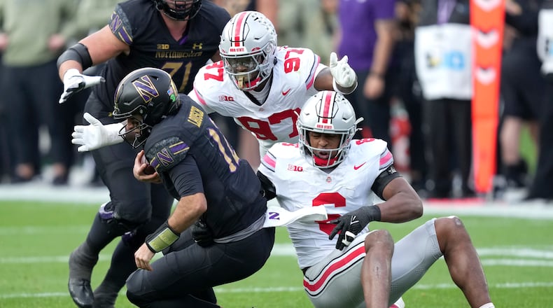 Ohio State safety Sonny Styles (6) and defensive end Kenyatta Jackson Jr. sack Northwestern quarterback Jack Lausch during the second half of an NCAA college football game at Wrigley Field on Saturday, Nov. 16, 2024, in Chicago. (AP Photo/Charles Rex Arbogast)