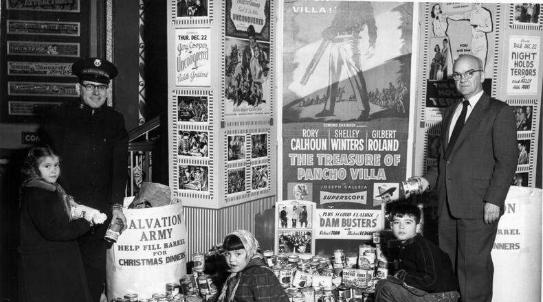 Children (left to right) making canned food donations during the December 1955 food collection in Hamilton at the Paramount theater are Carolyn Brashear, Barbara Brashear and Mike Brashear. Captain Raymond Hebert, Salvation Army director, and William Dodds, manager of the Paramount theater, look on. BUTLER COUNTY HISTORICAL SOCIETY/CONTRIBUTED